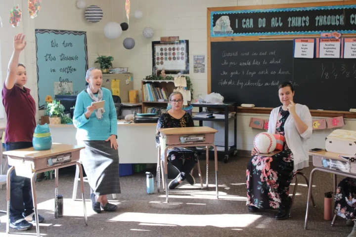 Students answering questions with desks positioned in a circle